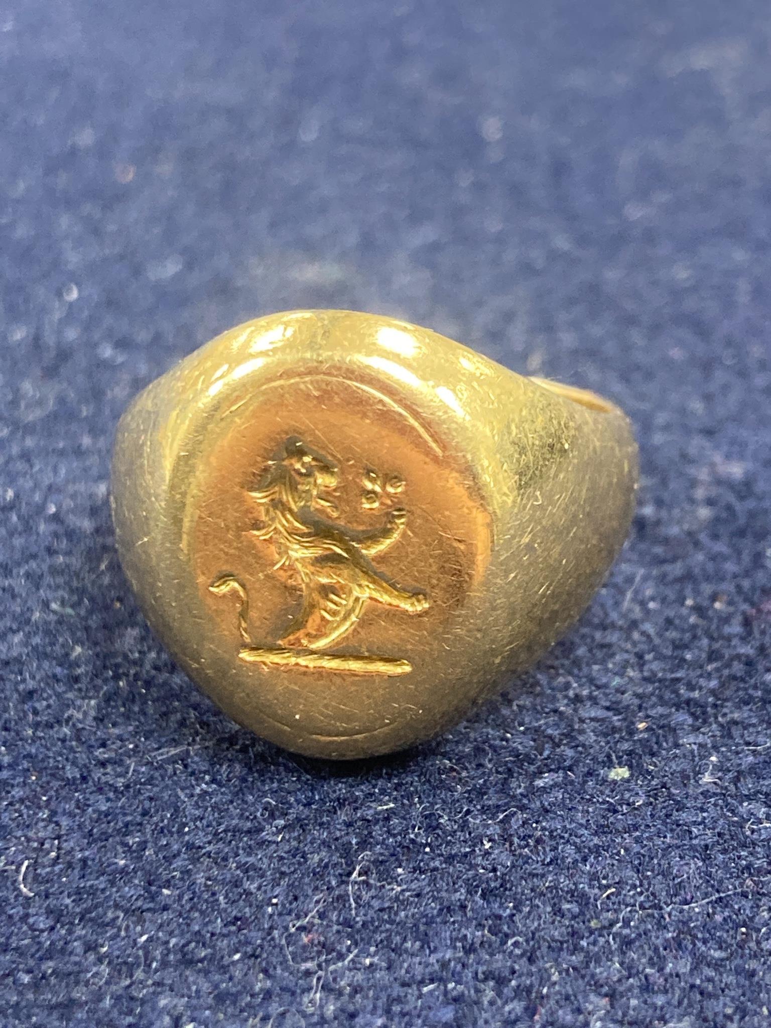 A Victorian yellow metal signet ring with engraved crest, size L, 14.7 grams and three other yellow metal and gem set rings , one a.f. gross 4.1 grams.